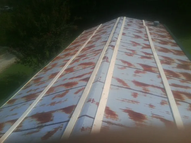 Rusted metal roof panels with new wood purlins before replacement — Storm Damage Roof Repair in Granville by Roofing Brothers
